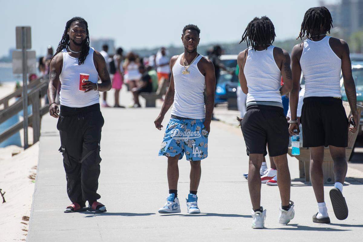 Spring breakers walk along Biloxi Beach during Black Spring Break on Saturday, April 12, 2025.