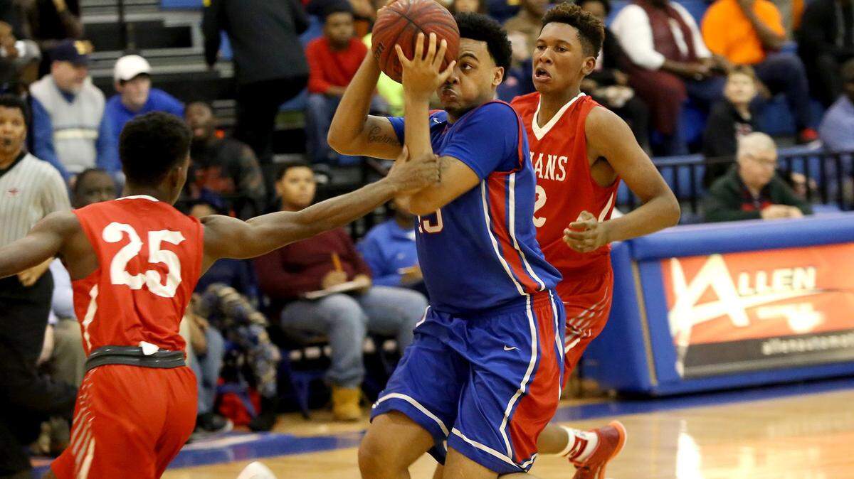 AMANDA McCOY/SUN HERALD 
 Biloxi's C.J. Bridges, left, gets ahold of Pascagoula's Jacques Belford as he drives to the basket during the final day of play at the Gulfport Hardwood Holiday Classic on Wednesday, December 30, 2015. Also pictured is Biloxi's Marques McGee, right.
