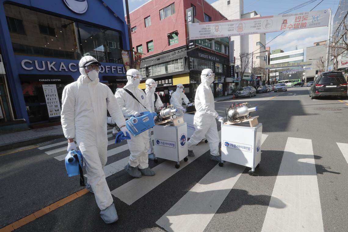 Workers wearing protective gears arrive to spray disinfectant as a precaution against the new coronavirus at a shopping street in Seoul, South Korea, Thursday, Feb. 27, 2020. As the worst-hit areas of Asia continued to struggle with a viral epidemic, with hundreds more cases reported Thursday in South Korea and China, worries about infection and containment spread across the globe.