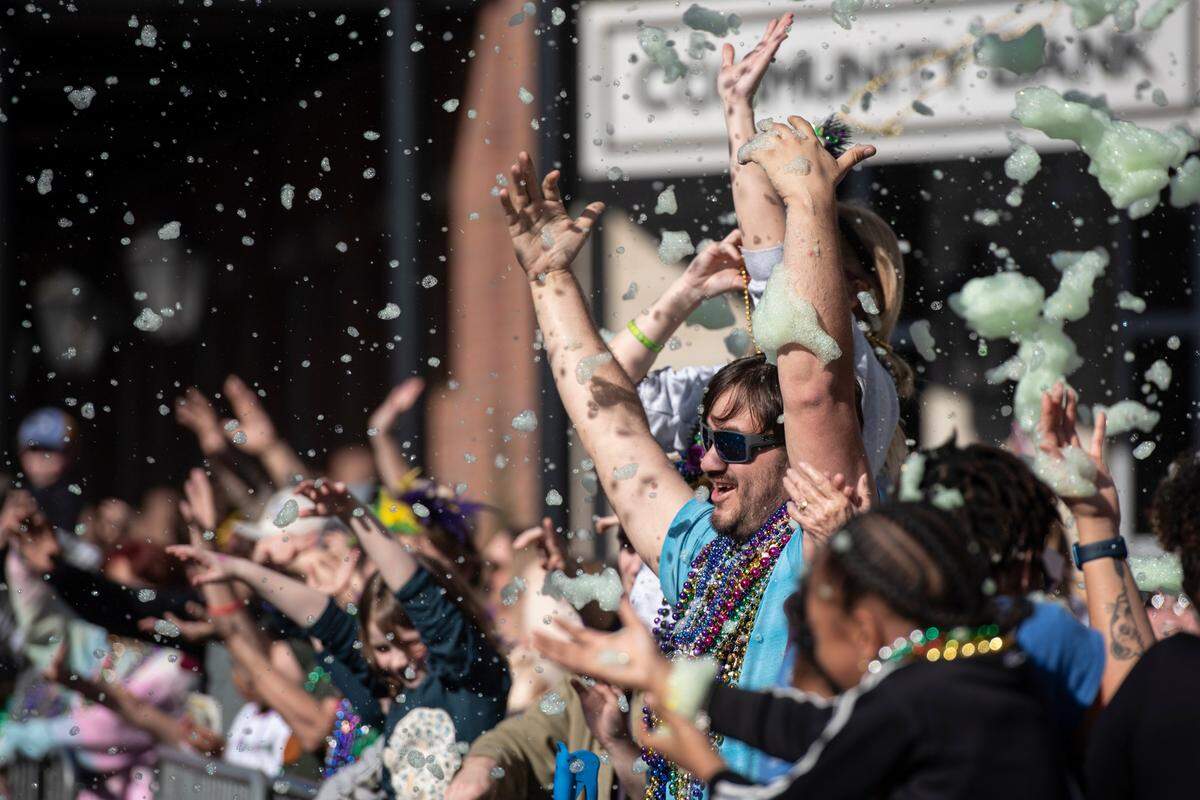 Parade-goers get hit with foam during the Gulf Coast Carnival Association’s Mardi Gras parade in Biloxi on Tuesday, Feb. 13, 2024.