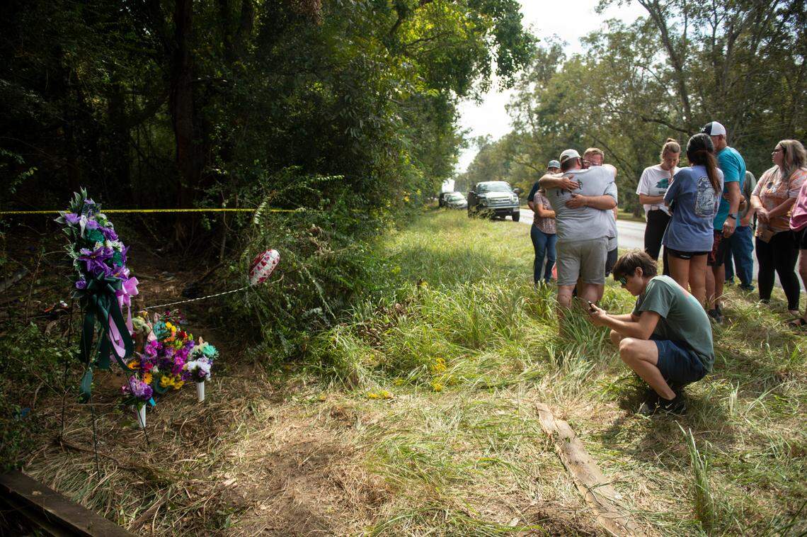 The family members of Baleigh Bowlin and Chloe Taylor gather around a memorial for the girls at the site of a fatal car accident that claimed the lives of both girls off of Highway 613 in Hurley on Monday, Oct. 17, 2022.