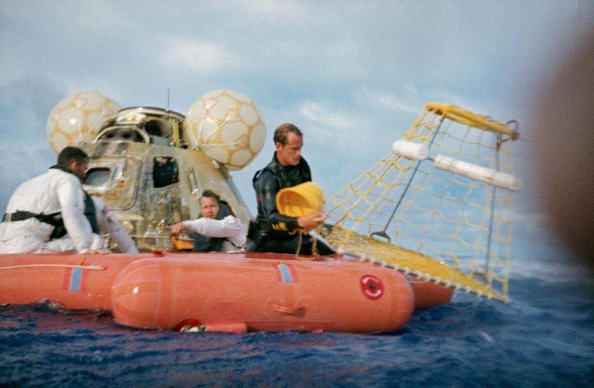 A water-level view of recovery operations for the Apollo 13 mission in the South Pacific Ocean. A U.S. Navy underwater demolition team swimmer prepares to assist Fred Haise into the net. Apollo 13 splashdown was just four miles from the USS Iwo Jima, prime recovery ship.