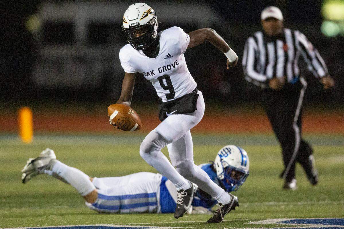 Oak Grove quarterback Aj Maddox evades tackle during a 6A playoff game at Greyhound Stadium in Ocean Springs on Friday, Nov. 18, 2022.