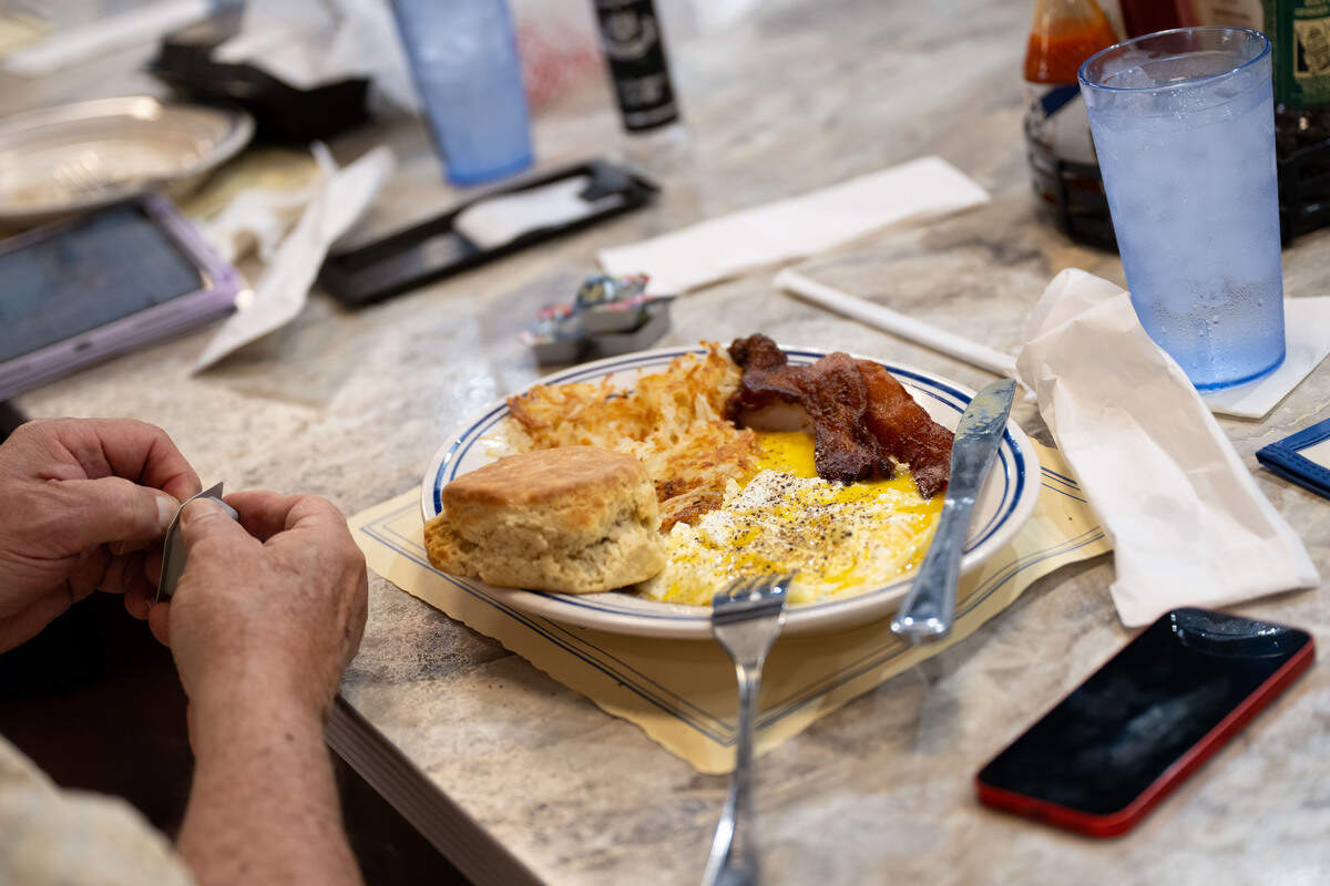 A breakfast dish with eggs, bacon, hash browns and a biscuit are served to a customer at the breakfast bar during the opening day of The Downtowner in Gulfport on Tuesday, June 9, 2026.