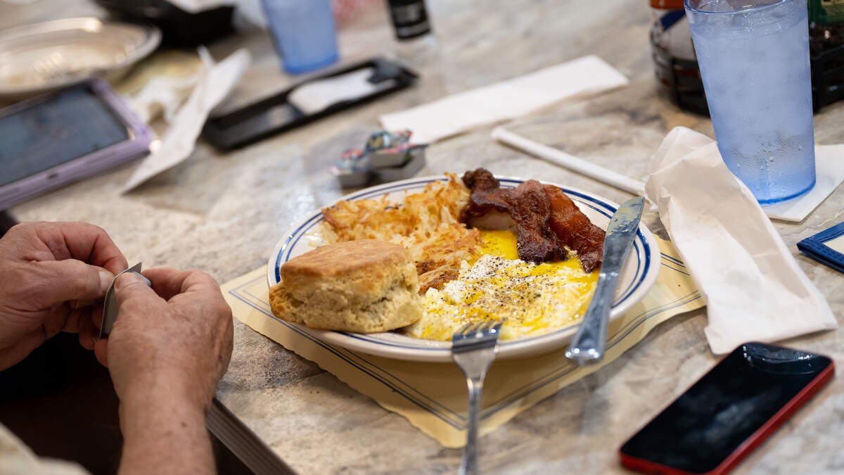 A breakfast dish with eggs, bacon, hash browns and a biscuit are served to a customer at the breakfast bar during the opening day of The Downtowner in Gulfport on Tuesday, June 9, 2026.