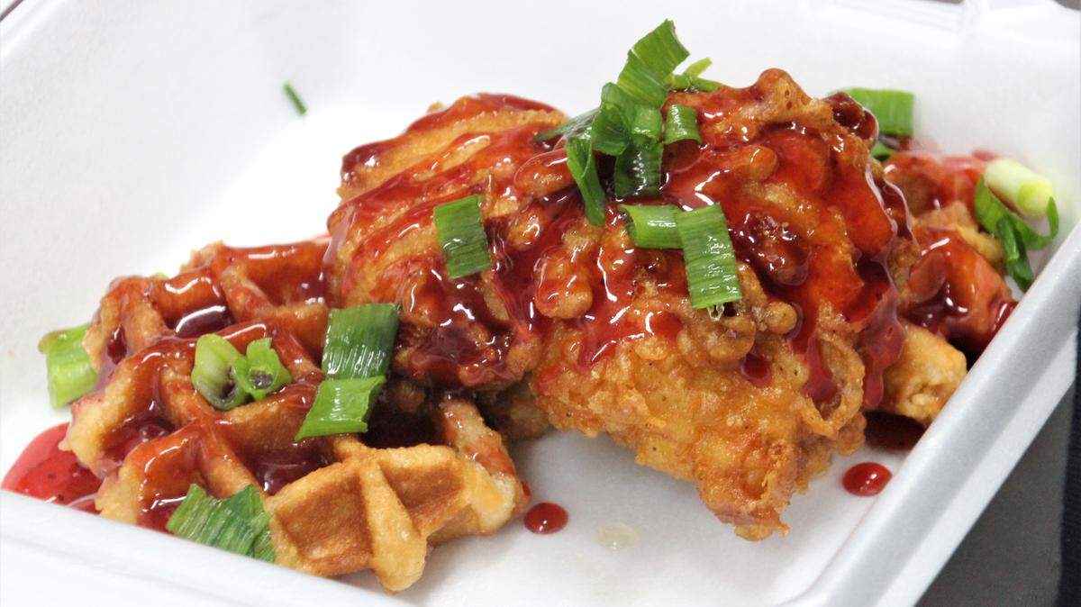 Waffles and fried chicken with a fiery sauce.