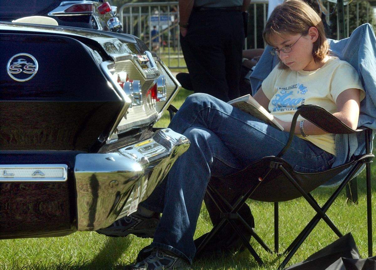 Twelve-year-old Amy Ardis of Mobile reads a novel during the final day of Cruisin’ The Coast on October 12, 2003 at Jones Park in Gulfport. Amy said she comes every year with her father John Ardis who owns a 1963 Impala Super Sport.