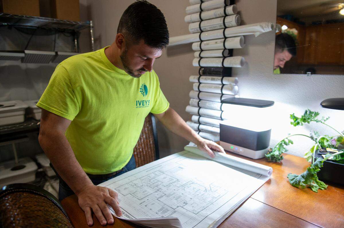 Alex Ivey, owner of Ivey’s Air Condition and Refrigeration, looks over plans for different projects at his home in Ocean Springs on Wednesday, Sept. 4, 2024. Ivey, who has a social media following for his videos about heating, ventilation and air conditioning, will compete next week in the finals of the HVAC National Championship.