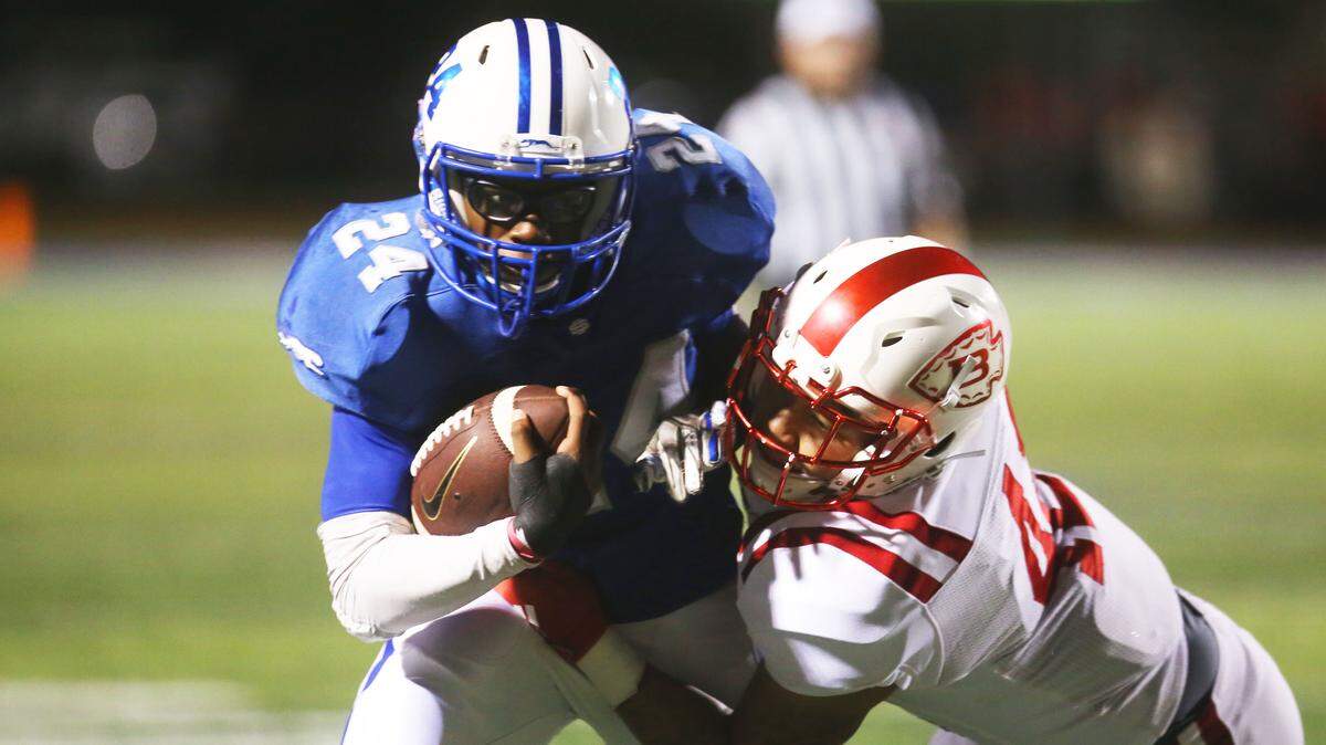 Ocean Springs running back Jahiel McCreary pushes a Biloxi defender as he runs the ball against the Indians Oct. 11, 2019.