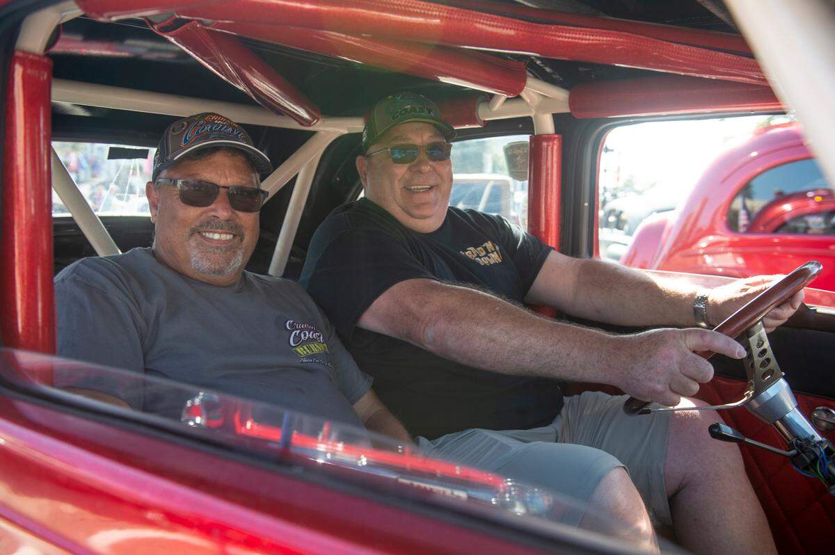 Martin Bishop, right, and his friend Rick Diaz sit inside Bishop’s 1952 Ford Anglia during View the Cruise at Cruisin’ The Coast in Gulfport on Sunday, Oct. 6, 2024.