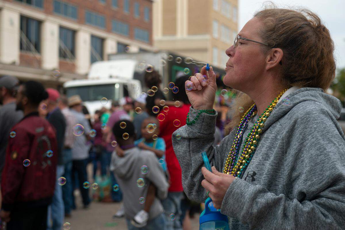 Paradegoers blow bubbles during the Krewe of Gemini parade in downtown Gulfport on Saturday, Feb. 10, 2024.