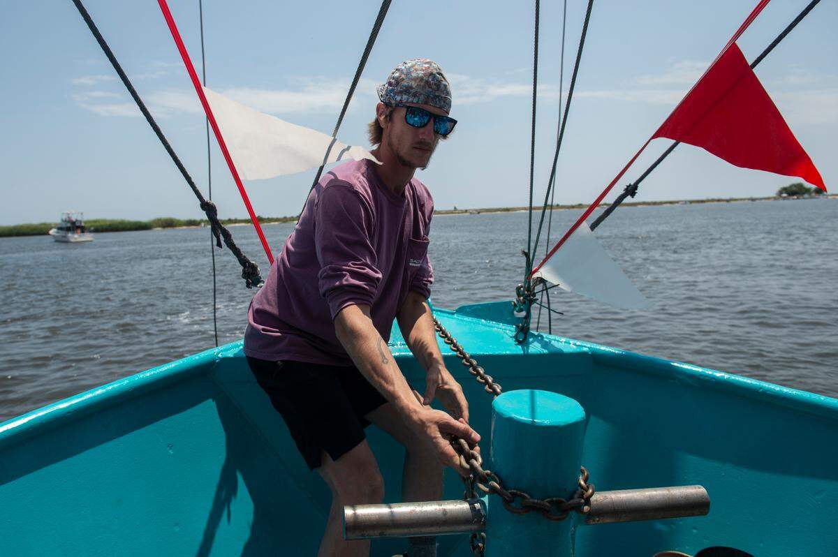 Vincent Bruhl drops anchor on his father-in-law’s boat, My Sons, during the Blessing of the Fleet in Biloxi on Sunday, May 28, 2023.
