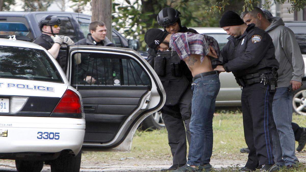 TIM ISBELL/SUN HERALD 
 
 Gulfport Police prepare to put a man into the back of a squad car after resolving a domestic crisis situation Thursday morning without incident.