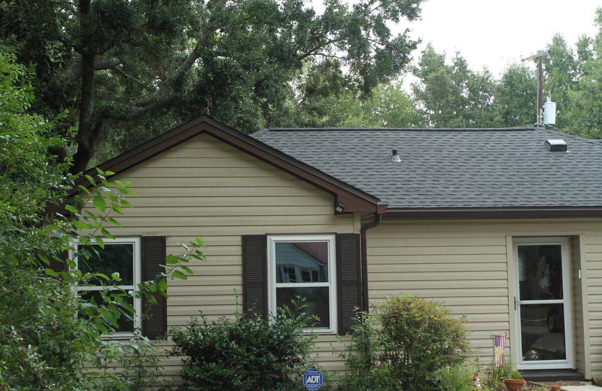 Insurance companies are paying closer attention to the condition of properties they insure against covered perils such as hurricanes. They sometimes recommend or require removal of trees or limbs within “fall distance” of a home. The Live oak behind this house was deemed at low risk of failure by an arborist and the homeowner has decided against removing it.