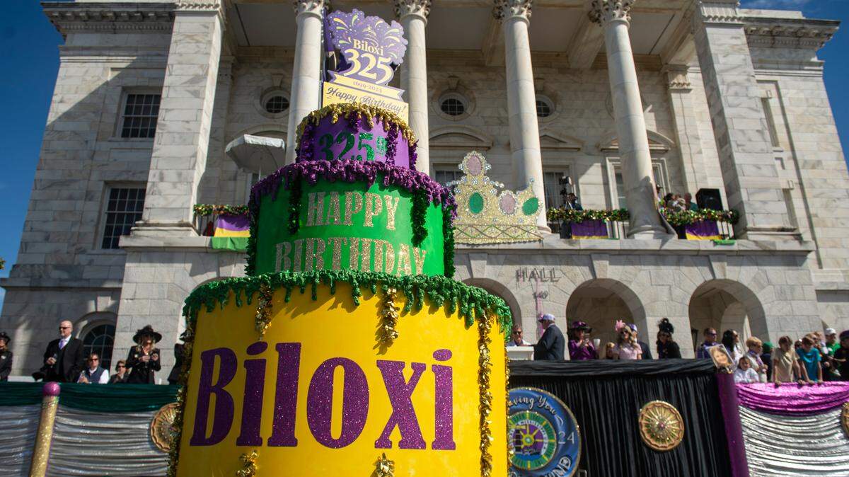 A birthday cake for the city of Biloxi’s 325th birthday passes by city hall during the Gulf Coast Carnival Association’s Mardi Gras parade in Biloxi on Tuesday, Feb. 13, 2024.