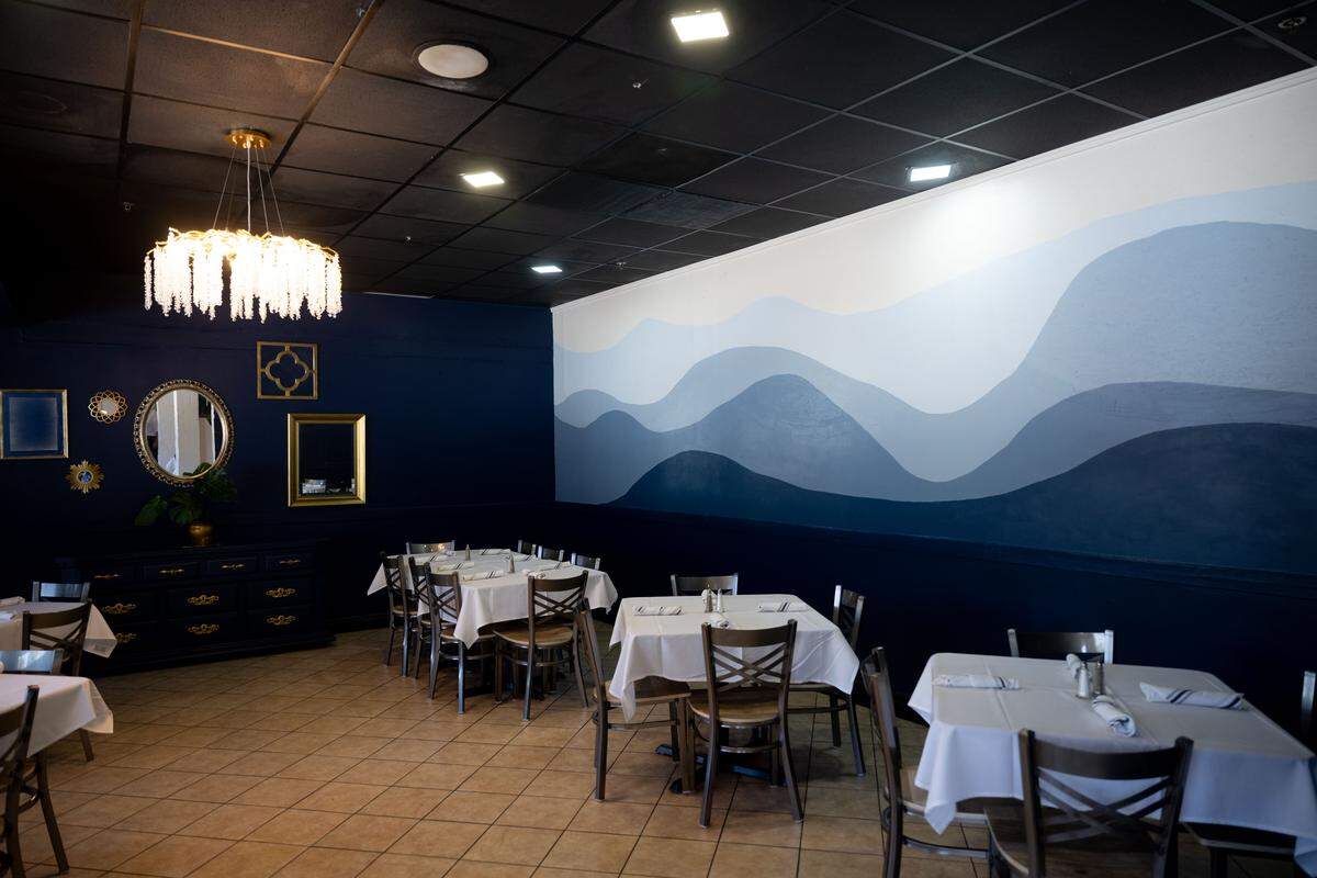 A blue dining room with a wave pattern painted on the wall at Coastal Kitchen in Long Beach on Tuesday, Feb. 24, 2026.