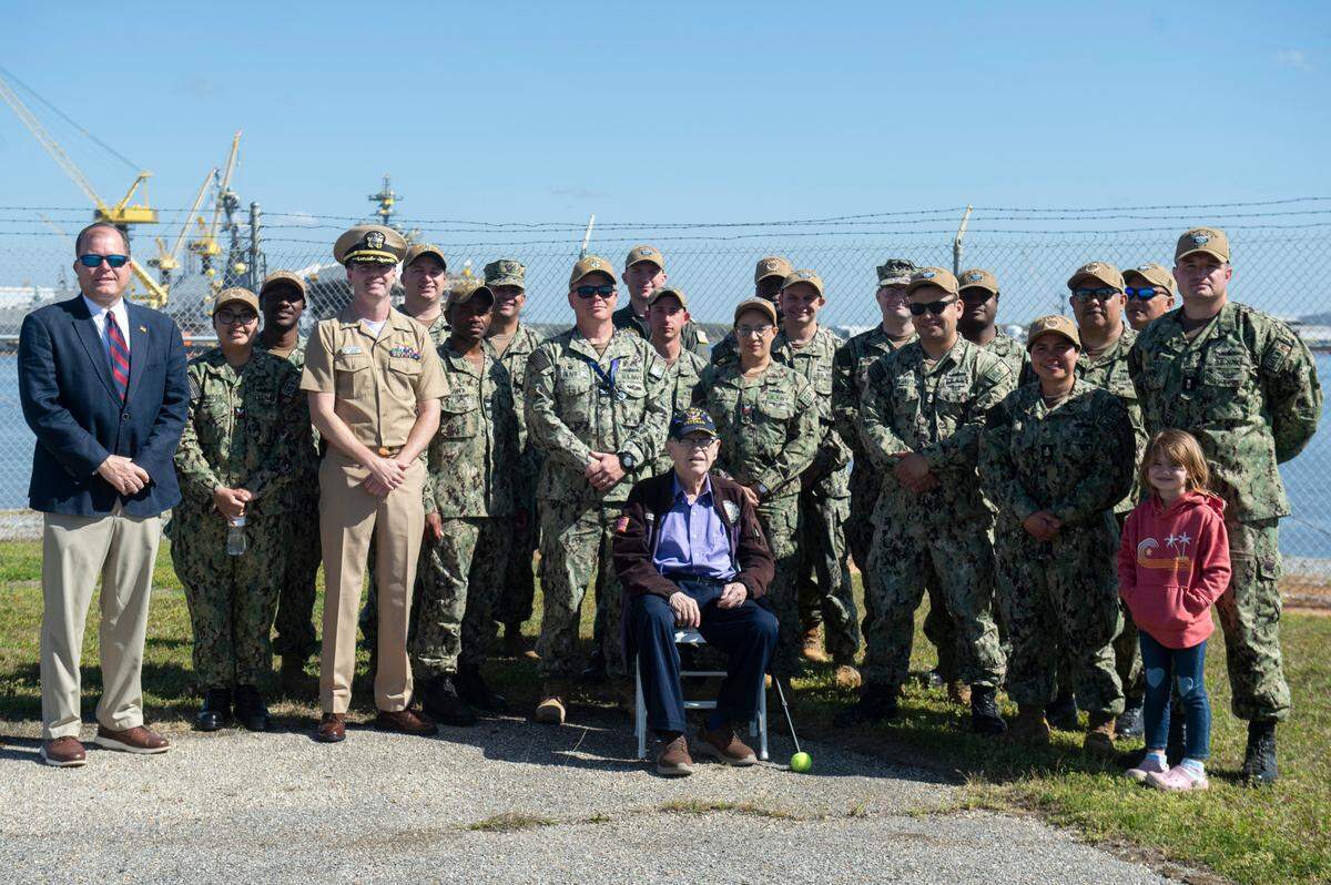 WWII veteran Alfred Lewis, center poses for a photo with Commander Ryan McGoldrick, Douglas Barton and the crew of the USS Bougainville during a ceremony for Lewis at Singing River Island in Pascagoula on Saturday, March 22, 2025.