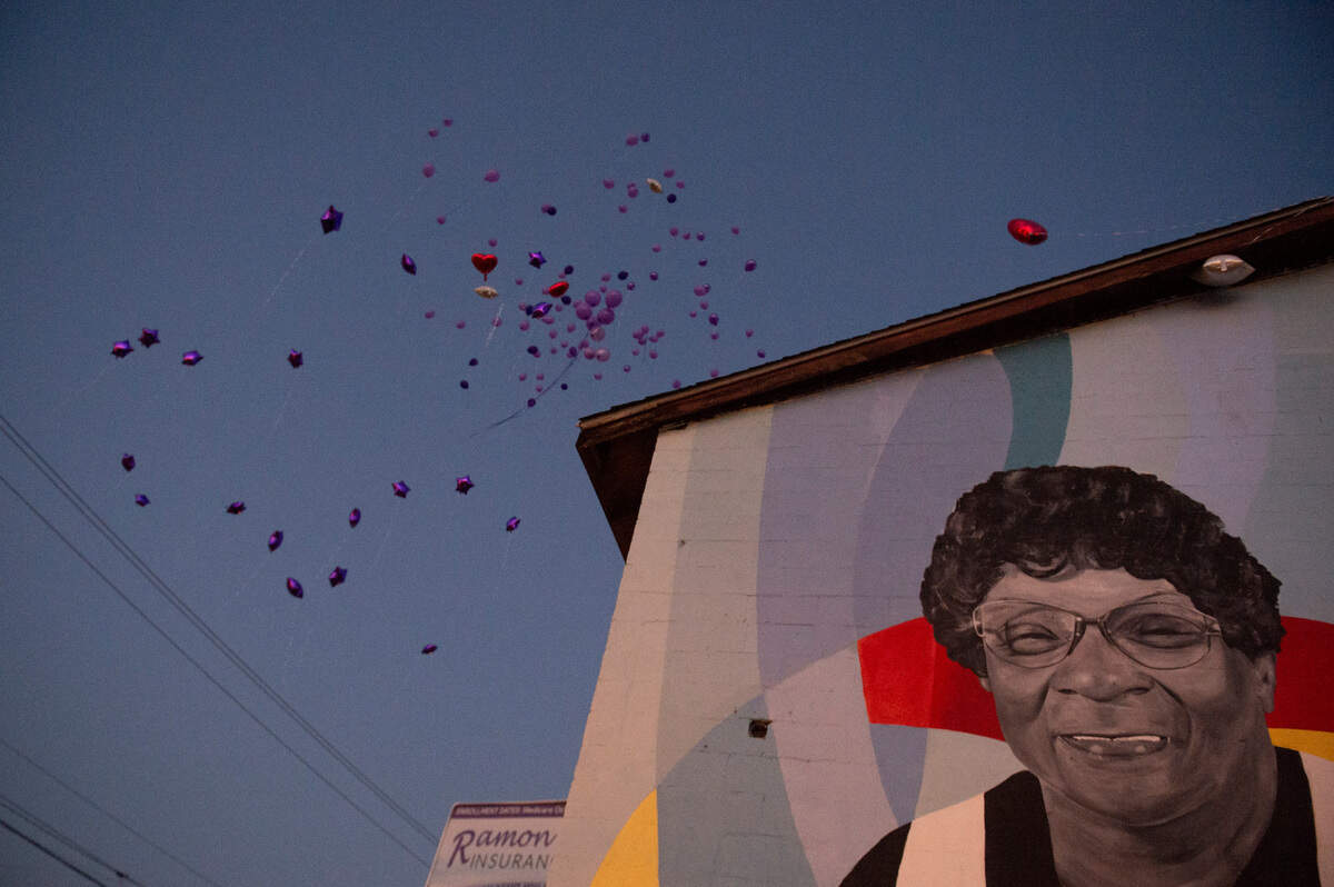 A mural of Inez Thomas painted on the side of her former restaurant looks out as balloons are released into the air in her honor on Friday, Oct. 22, 2021.