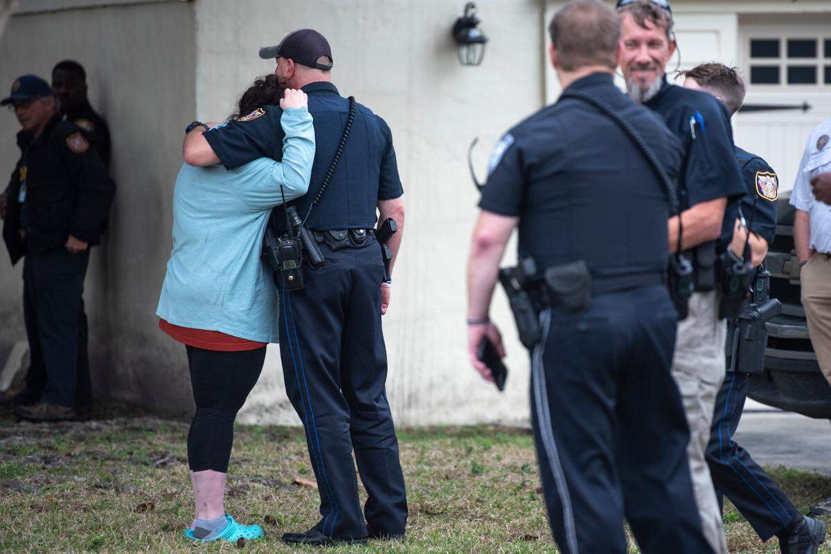 Members of law enforcement embrace and comfort each other as the body of Sgt. Steven Robin is taken to Edmond Fahey funeral home on Wednesday, Dec. 14, 2022. Robin was killed along with another officer while on duty.
