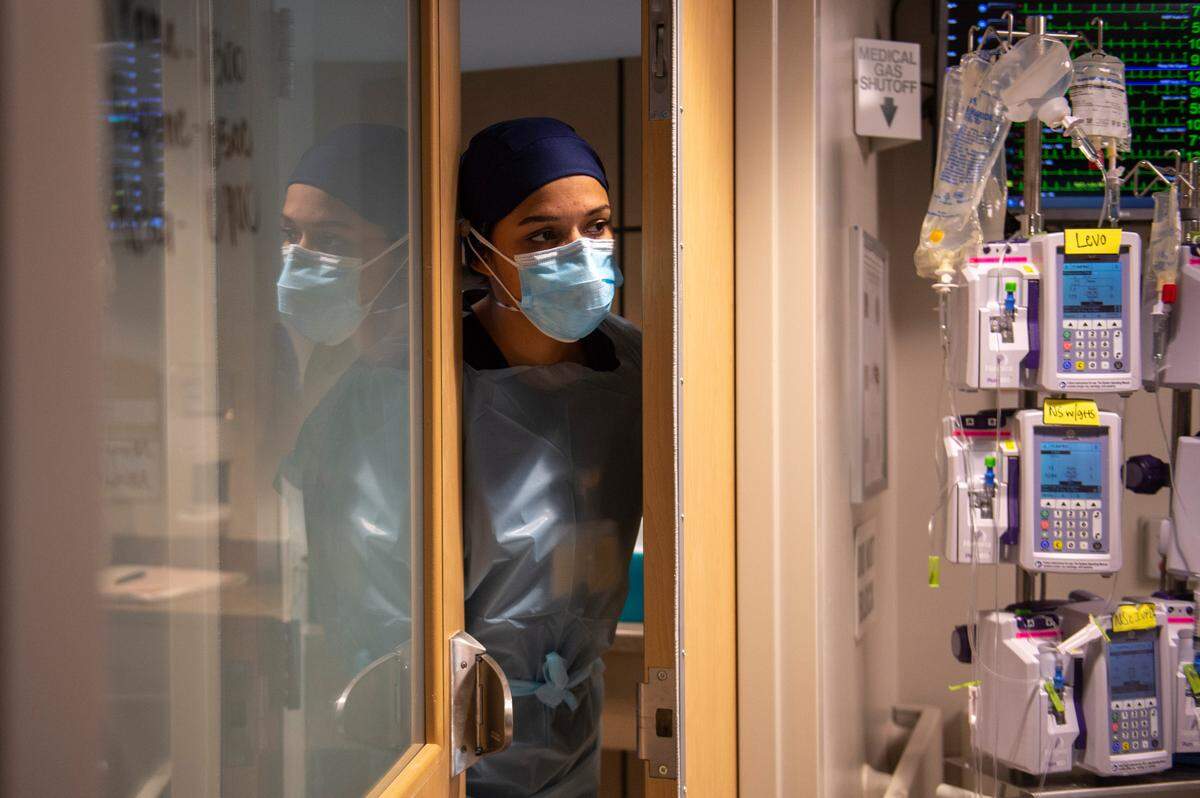 A nurse peers out of a COVID-19 patient’s room in the ICU at Memorial Hospital in Gulfport on Wednesday, Aug. 11, 2021. Hospitals along the MS Gulf Coast have few to no ICU beds available.