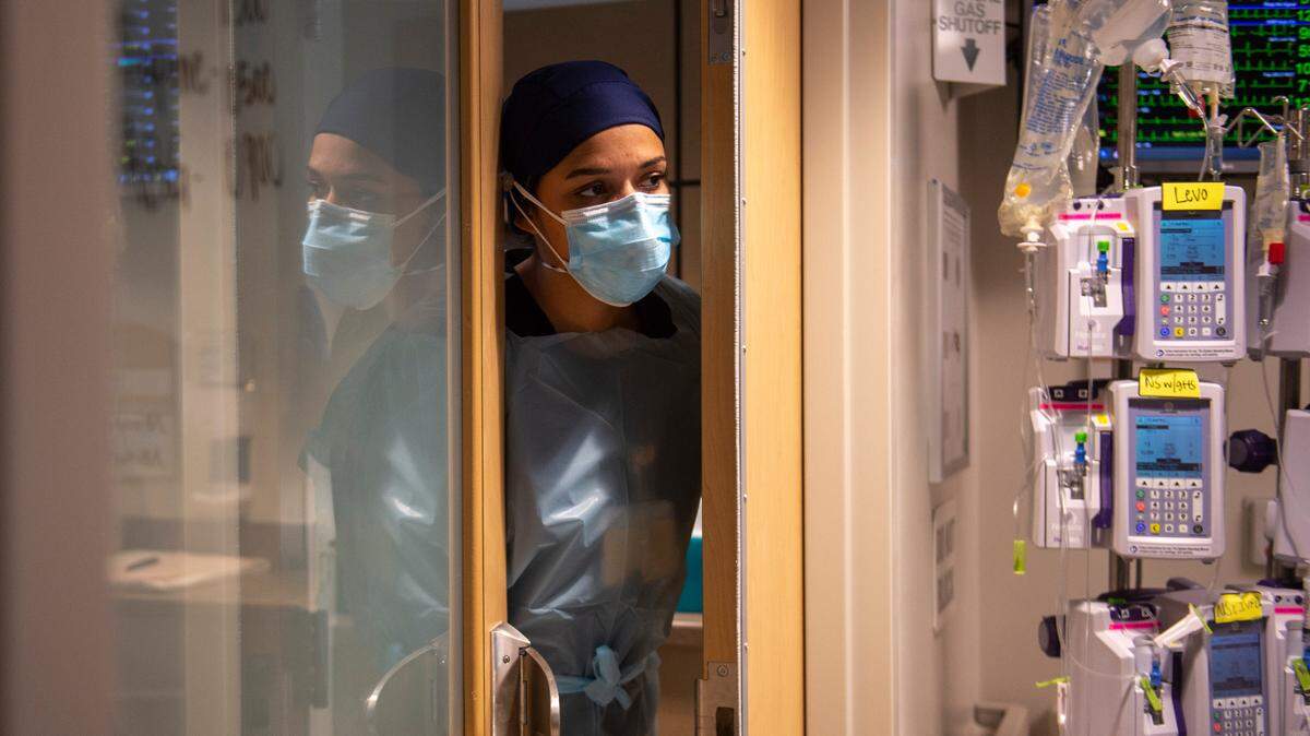 A nurse peers out of a COVID-19 patient’s room in the ICU at Memorial Hospital in Gulfport on Wednesday, Aug. 11, 2021. Hospitals along the MS Gulf Coast have few to no ICU beds available.