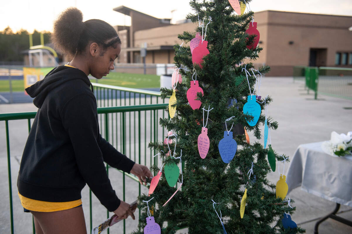 Students place notes on a Christmas tree during a candlelight vigil in honor of three Gautier High School graduates, Se’Dhari Saniya Watson-Person, Kyla “Muffin” Watkins, and Tatyanna Richmond who were involved in a fatal crash, at Gautier High School in Gautier on Thursday, Dec. 7, 2023. Watson-Person and Watkins were killed in the crash.