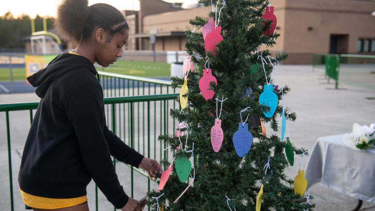 Students place notes on a Christmas tree during a candlelight vigil in honor of three Gautier High School graduates, Se’Dhari Saniya Watson-Person, Kyla “Muffin” Watkins, and Tatyanna Richmond who were involved in a fatal crash, at Gautier High School in Gautier on Thursday, Dec. 7, 2023. Watson-Person and Watkins were killed in the crash.