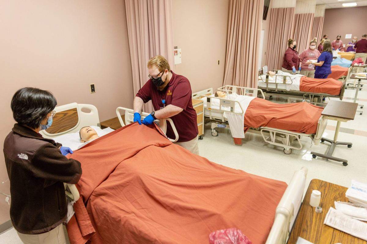Nursing students practice wound care with nursing mannequins during class at Pearl River Community College in Poplarville, Miss., Wednesday, March 2, 2022.