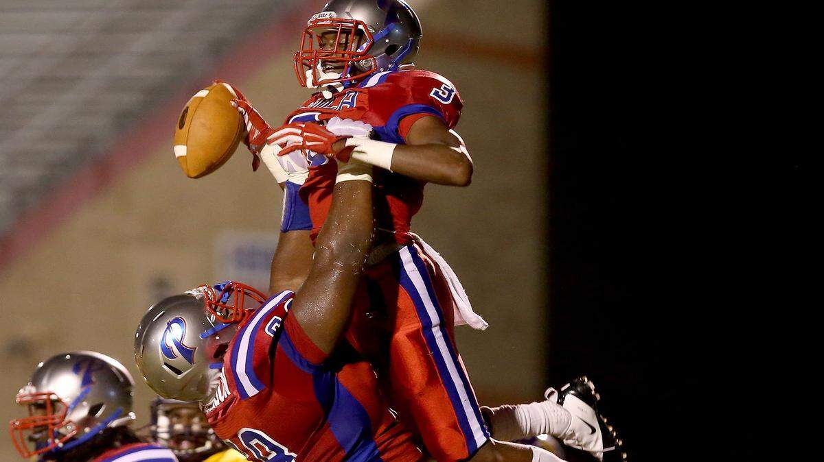 AMANDA McCOY/SUN HERALD 
 Pascagoula's James Jackson lifts teammate Cartreal Davison into the air after Davison scored a touchdown against Hattiesburg on Friday, October 16, 2015, at Pascagoula High.
