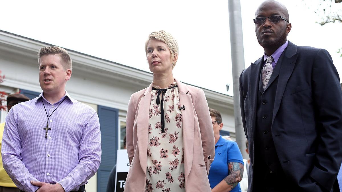 Mississippi Rising Coalition President Lea Campbell, center, stands with the Rev. Cuttino Alexander, left, and TNathan Fairley, a board member of Mississippi Rising Coaltion, to address the media after she received an emailed video from the United Dixie White Knights.