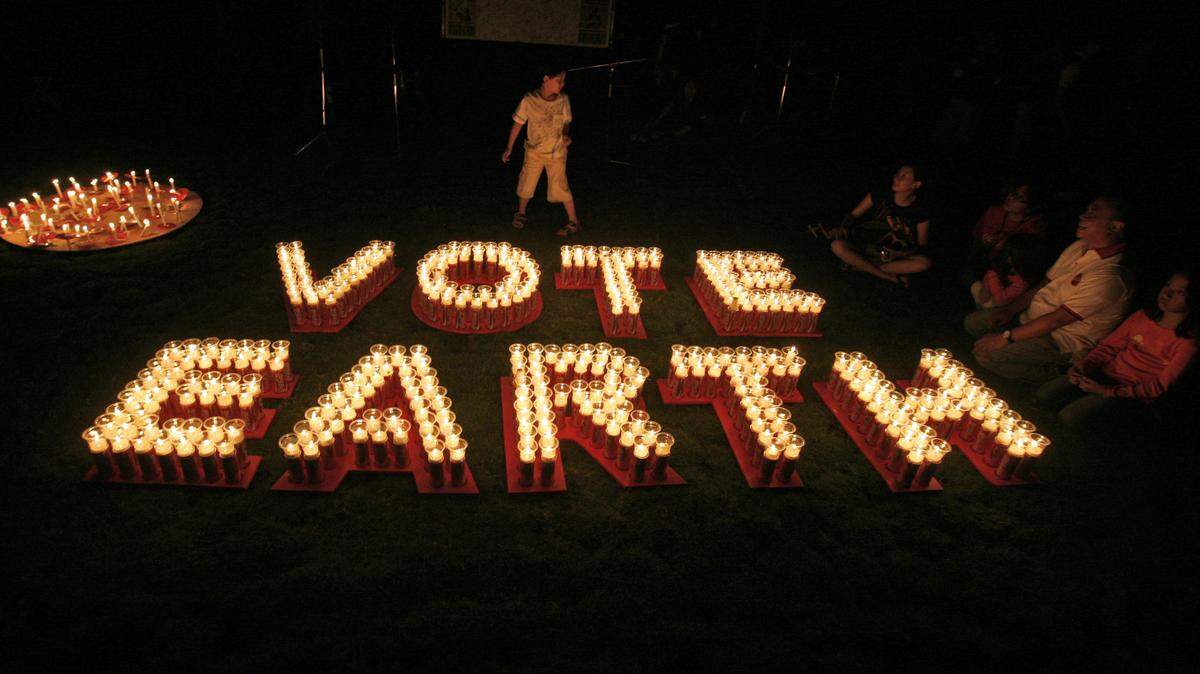 ASSOCIATED PRESS/2009 
 An Indonesian family sits near candles as lights are turned off during a candlelight vigil marking Earth Hour in 2009. Harrah's Gulf Coast and Beau Rivage Resort & Casino in Biloxi will join the observance Saturday by dimming lights from 8:30-9:30 p.m.