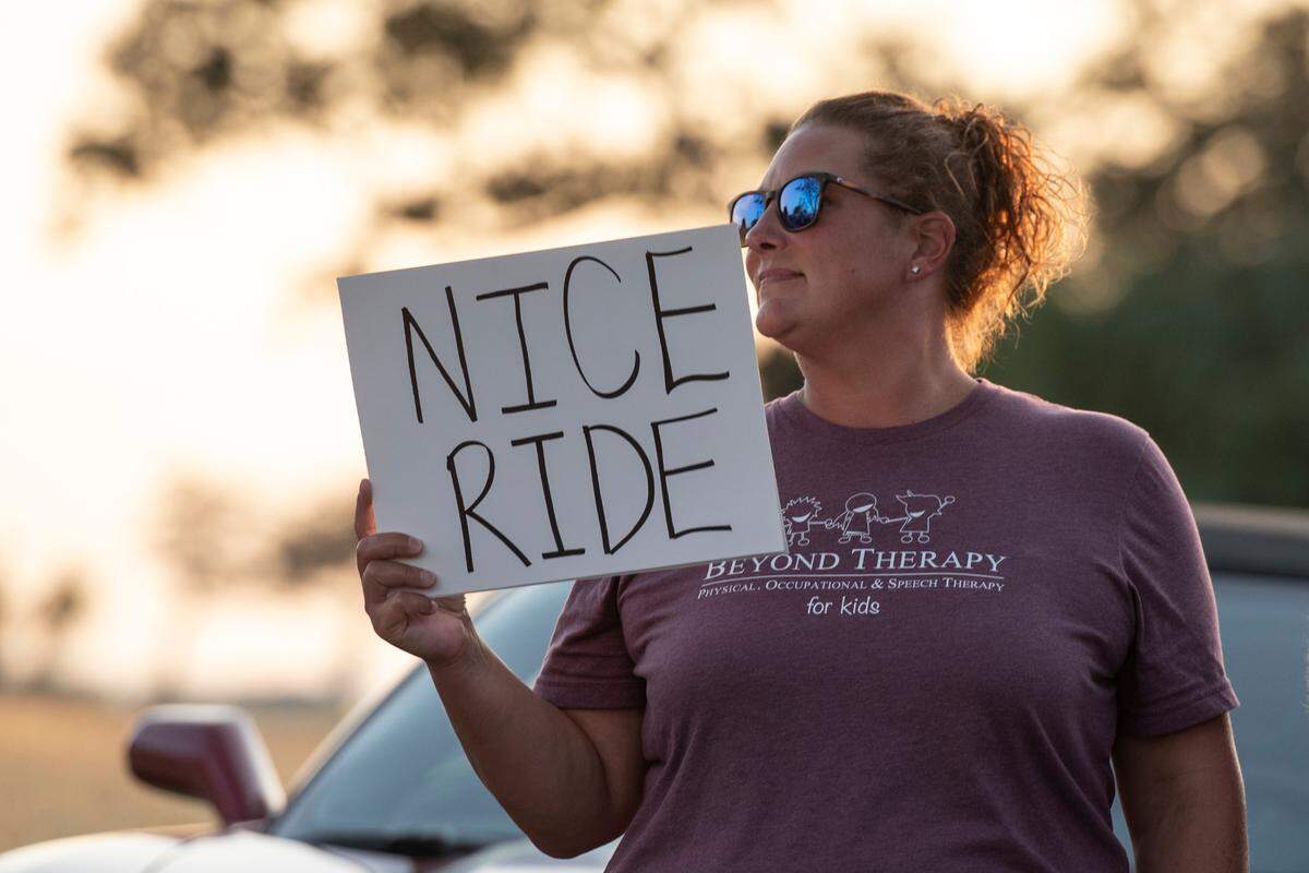 A spectator holds a sign during the Long Beach Parade during Cruisin’ The Coast 2024. Other events will be held in Gautier, Gulfport and D’Iberville.