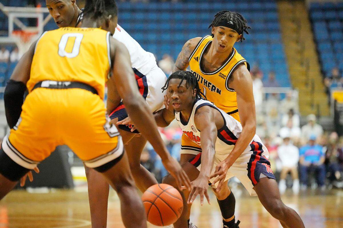 Southern Mississippi guard Austin Crowley (1) reaches around Mississippi guard Jaylen Murray, bottom right, and knocks the ball away during the first half of an NCAA college basketball game, Saturday, Dec. 23, 2023, in Biloxi, Miss. (AP Photo/Rogelio V. Solis)