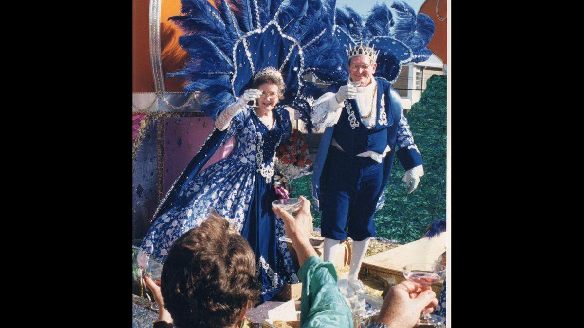 Leda Onita Mallery and King Jupiter Lewis Shanks toast the reviewing stand in front of Gulfport City Hall at the Krews of Gemini 1990 Mardi Gras Parade.