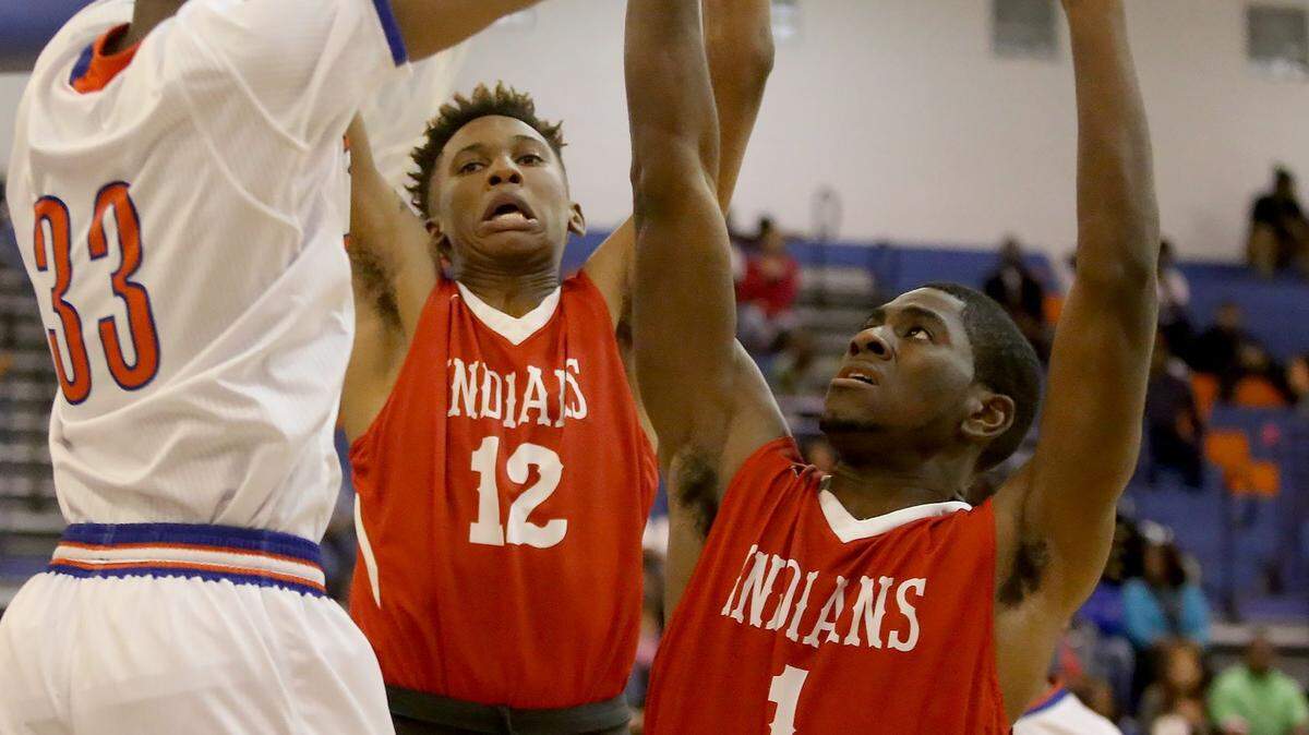 AMANDA McCOY/SUN HERALD 
 Biloxi's Marques McGee, 12, and Jordan Lewis, 1, try to block Gulfport's Raekwon Murphy's pass on Friday, Feb. 12, 2016, at Gulfport High.
