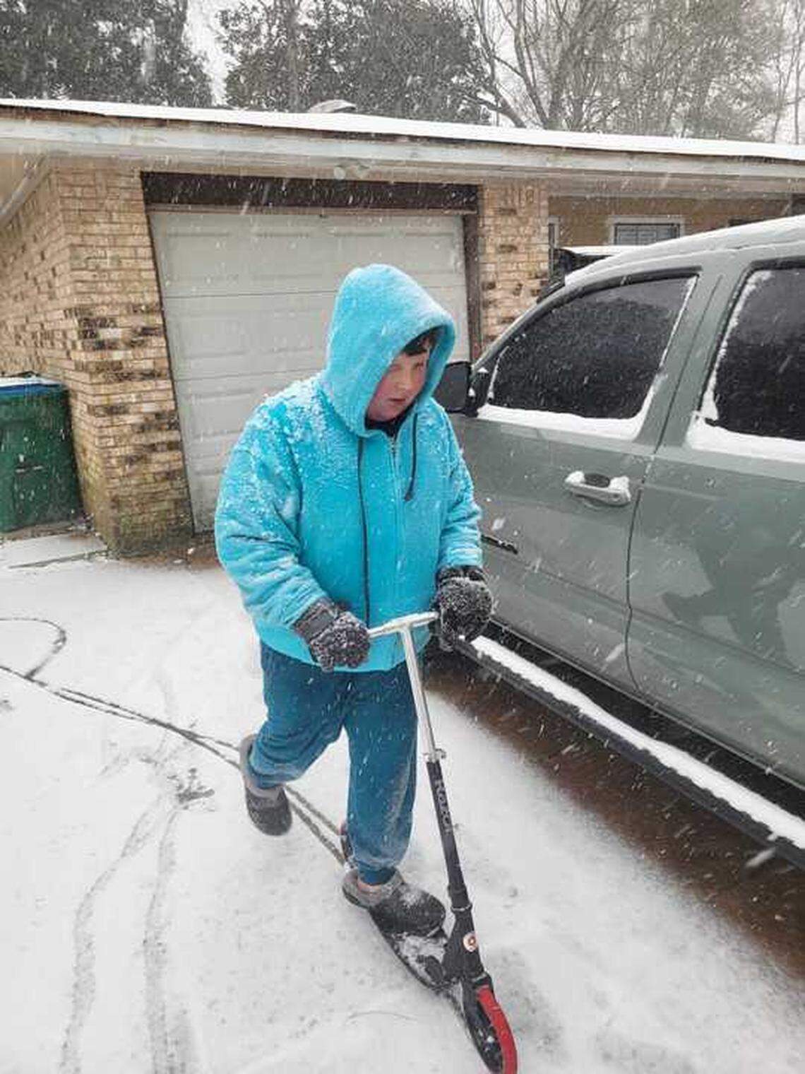 Joshua Larson, 11, rode his scooter Tuesday morning through the snowy streets of Gautier. “It’s really fun,” he said. “I’ve never experienced it.”
