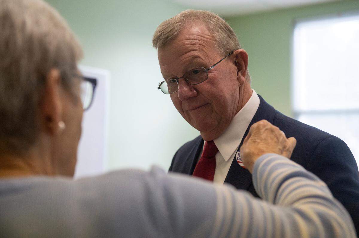 A poll worker gives Jackson County Sheriff Mike Ezell, the Republican candidate for Mississippi’s 4th Congressional District, a voting sticker after he voted at First Presbyterian Church in Pascagoula on Tuesday, Nov. 8, 2022.
