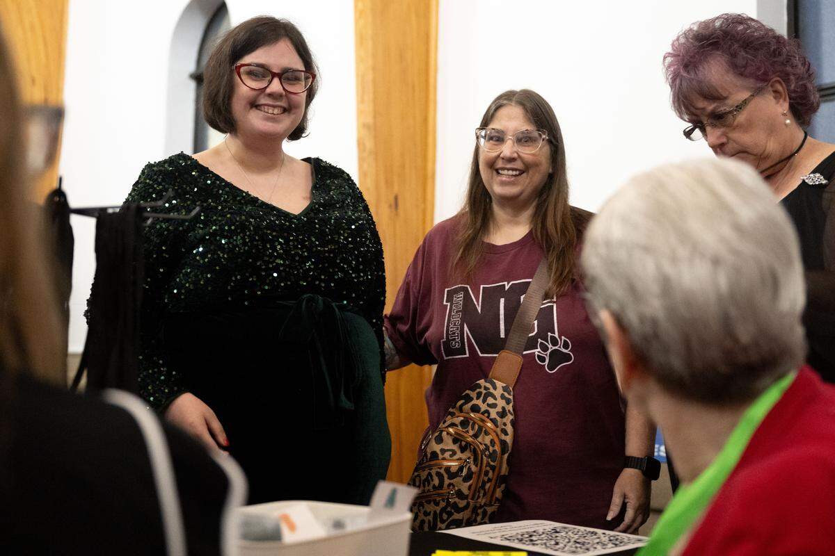 Courtnie Allen, left, and her mother Stacie Allen, right, pick up their badges during Night to Shine at Woolmarket Baptist Church on Friday, Feb. 13, 2026.
