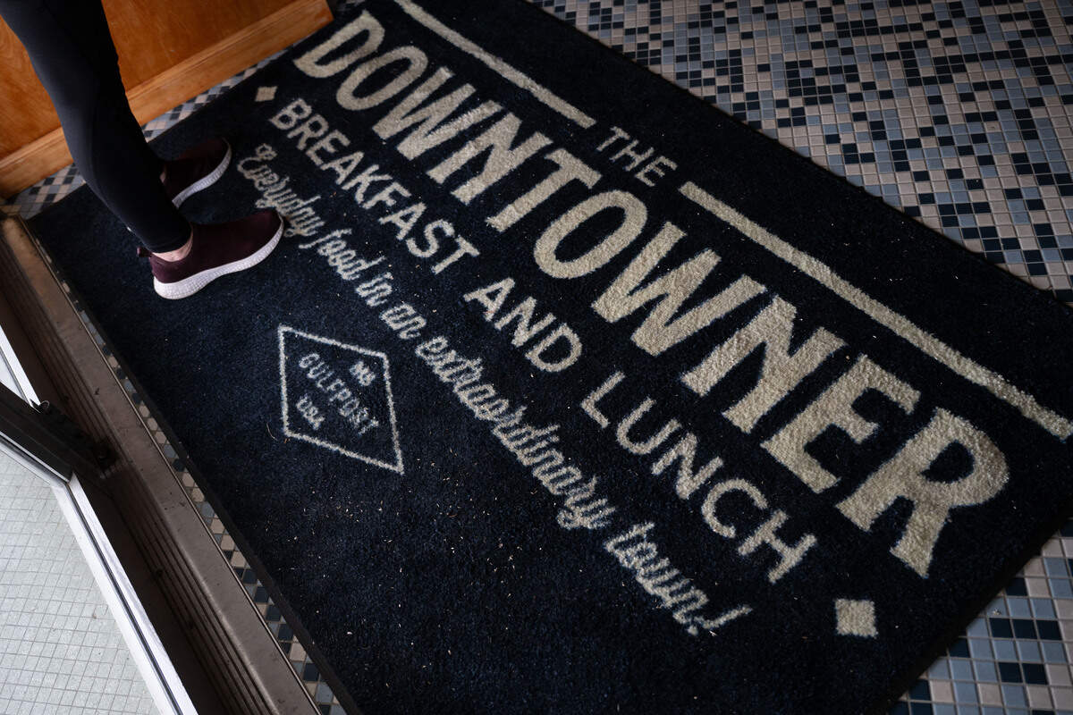 A customer stands on a branded mat as she waits for a table during the opening day of The Downtowner in Gulfport on Tuesday, June 9, 2026.
