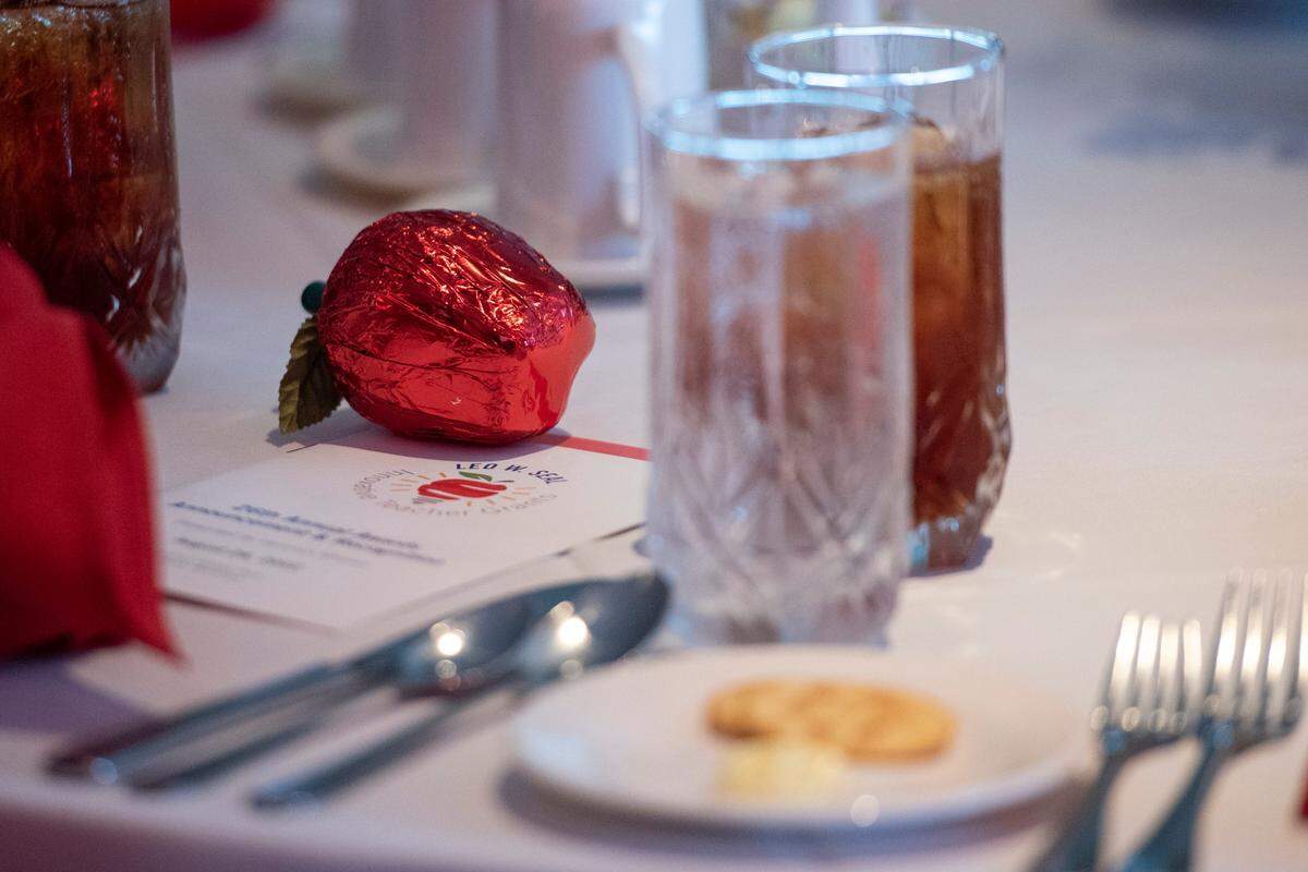 A chocolate apple wrapped in red foil sits on a table during the Leo W. Seal awards luncheon at the Great Southern Club in Gulfport on Friday, Aug. 26, 2022. The apples are given to all attendees and award winners, who are all educators.