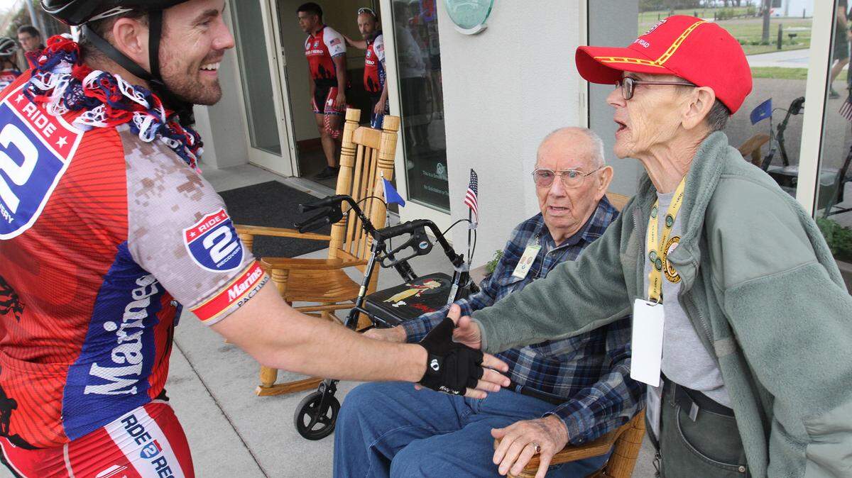JOHN FITZHUGH/SUN HERALD 
 Ride 2 Recovery rider Rob Kugler greets Armed Forces Retirement Home residents Carl and Clair Smith during a brief visit to the Gulfport retirement home Thursday March 10, 2016.