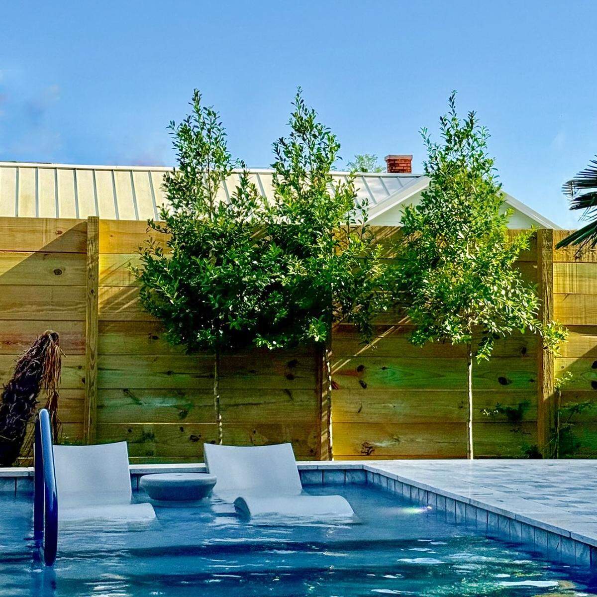 The heated swimming pool at The Pullman House in Ocean Springs has built-in seats where guests can relax.