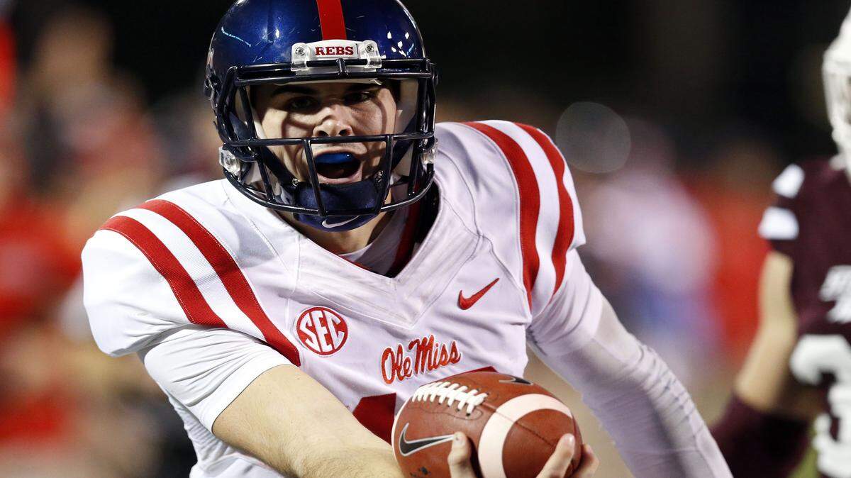 Ole Miss quarterback Chad Kelly (10) lunges forward with the ball for a 27-yard touchdown run in the first half of an NCAA college football game against Mississippi State in Starkville, Miss., Saturday, Nov. 28, 2015. (AP Photo/Rogelio V. Solis)