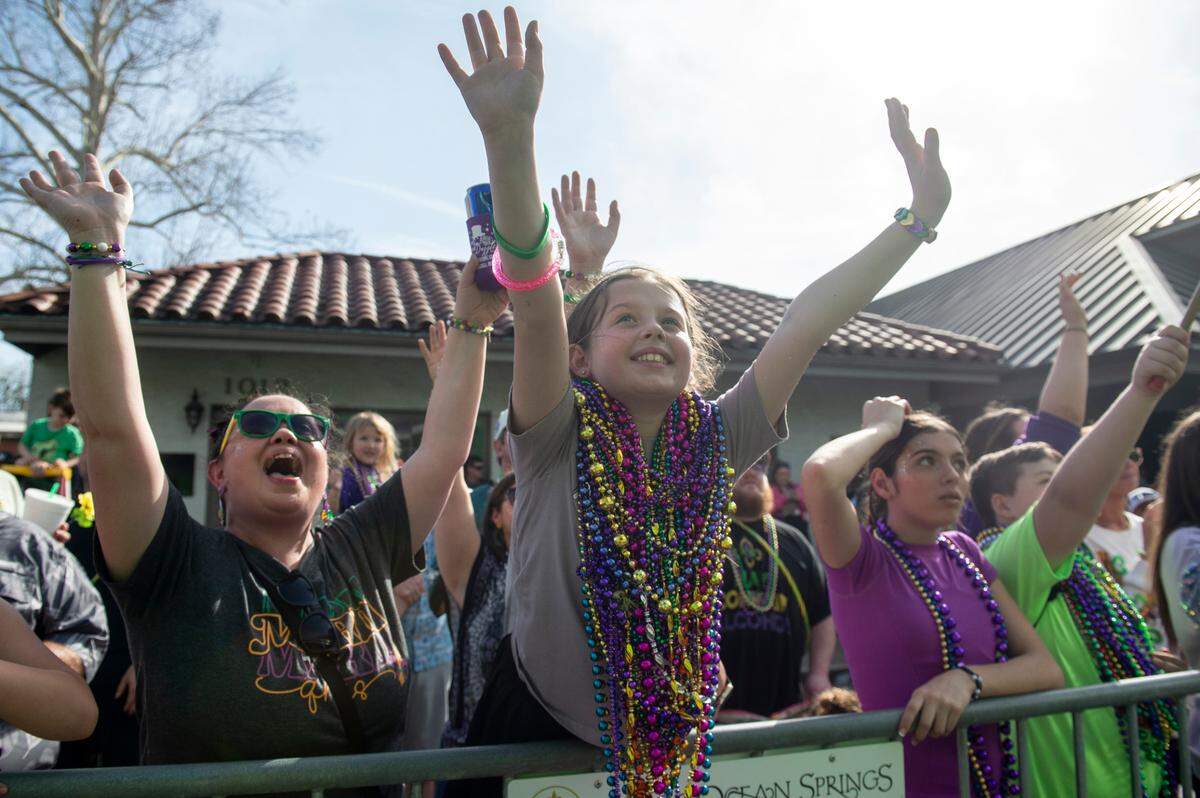 Parade watchers cheer for throws during the Ocean Springs Elks Club Mardi Gras Parade in Ocean Springs on Saturday, Feb. 15, 2025. The parrade is on despite the cold weather, but there won’t be many short sleeves this year.