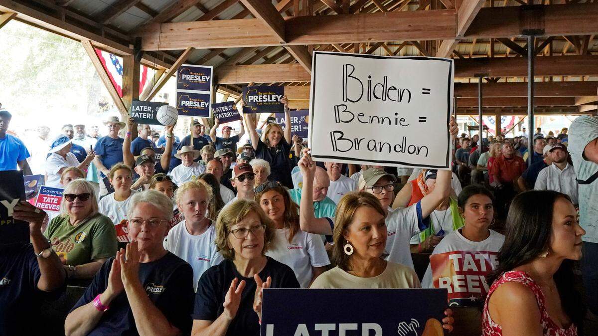 A person holds a sign in July that links President Joe Biden to Democratic U.S. Rep. Bennie Thompson of Mississippi and Brandon Presley, the Democratic nominee for Mississippi governor at the Neshoba County Fair near Philadelphia. (AP Photo/Rogelio V. Solis)