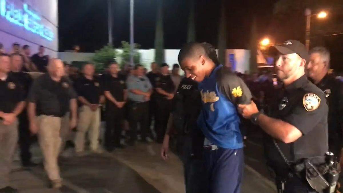 Darian Atkinson is escorted into the Biloxi Police Department on Monday night.