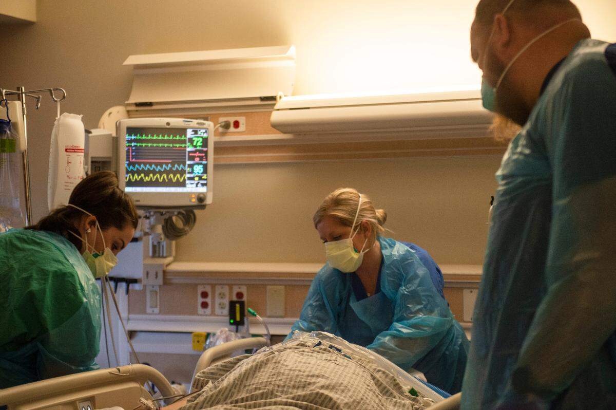 Nurses work to flip a COVID-19 patient onto his stomach inside the ICU at Singing River Health System hospital in Ocean Springs on Tuesday, July 27, 2021.