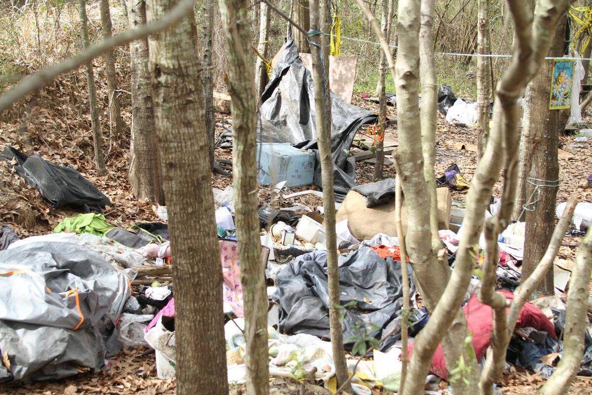 In this file photo from 2019, trash is piled in mounds throughout the woods inhabited by homeless people just north of downtown Gulfport.
