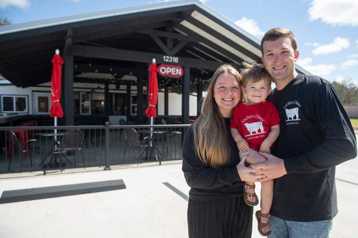 Luckies Diner owners Byren, right, and Hanna Ferguson pose for a portrait with their son Riley outside the new diner in Vancleave.