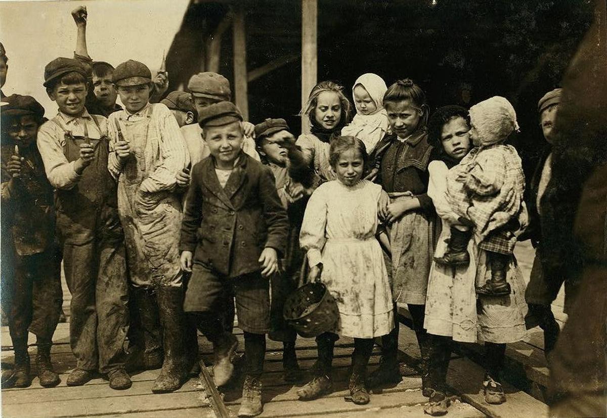 Children shuck oysters and tend babies in 1911 at the Pass Packing Co. in Pass Christian. Decades after the factory closed, beachgoers reported seeing and talking to a boy in old-fashioned clothes, who would mysteriously disappear.